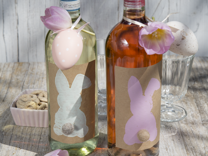 Die Etiketten sind eine süße Geschenkidee für das Osterfest. Hasen-Etiketten mit Bommelschwanz auf Glasflaschen